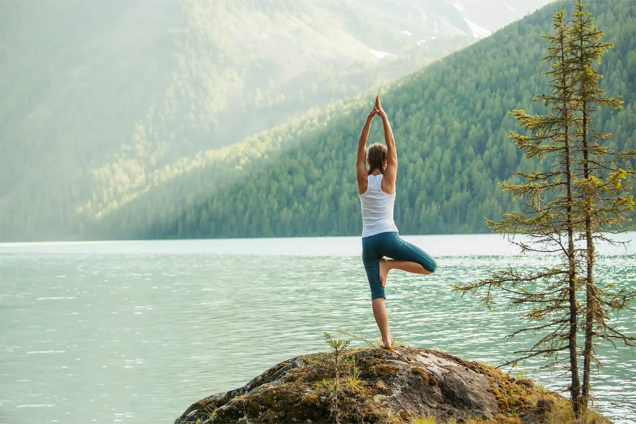 Frau macht Yoga an einem See